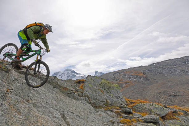 istock Mountain biker rides down rock slab below the Matterhorn mountain 1159859424