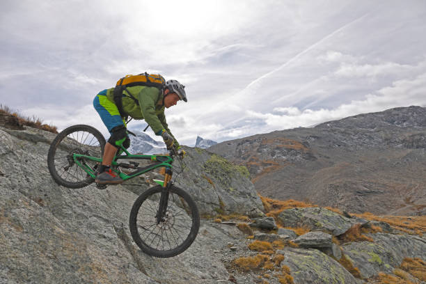 istock Mountain biker rides down rock slab below the Matterhorn mountain 1159859482