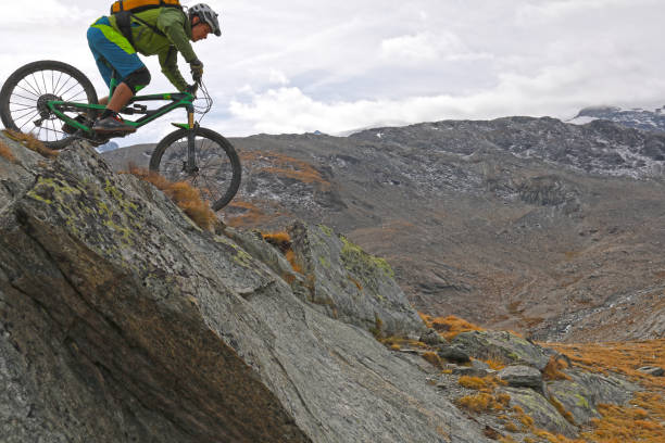 istock Mountain biker rides down rock slab below the Matterhorn mountain 1159859523