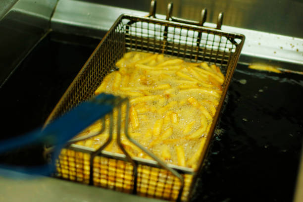 istock potato chips frying  in a deep fat fryer 1159859539