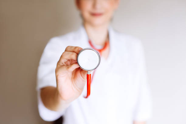 Young medical professional uses instrument to check on patient