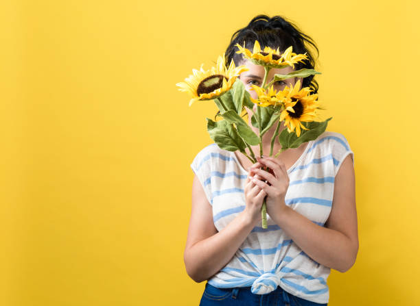 istock Young woman with sunflowers 1159859747