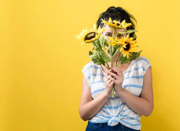 Photo of Young woman with sunflowers