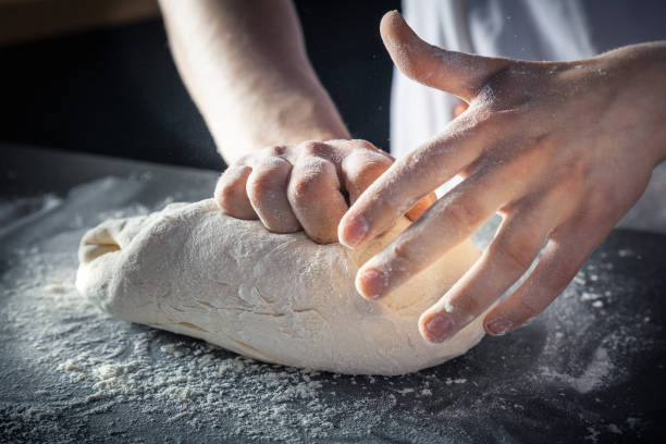 istock Chef prepares the dough with flour. Hands kneading raw dough Horizontal. Copy space. Gluten free dough for pasta, bakery or pizza. Baker workplace. Chef makes dough. Culinary, cooking, bakery concept 1159861155
