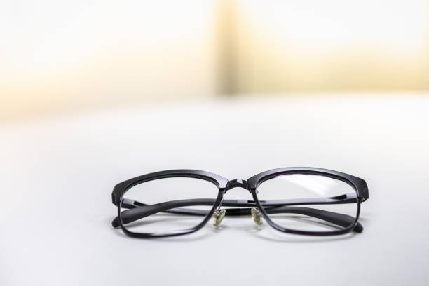 istock Close up of used reading glasses on white table with copy space for text. 1159862281