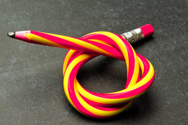 istock Flexible pencil on a textured cardboard background. Bent pencils two-color 1159862370