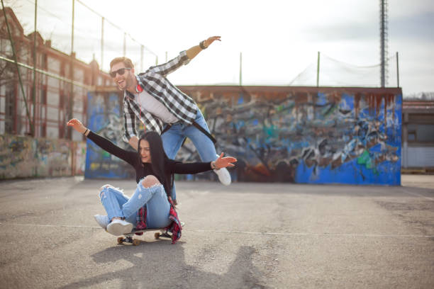istock Young couple having fun with a skateboard 1159865442