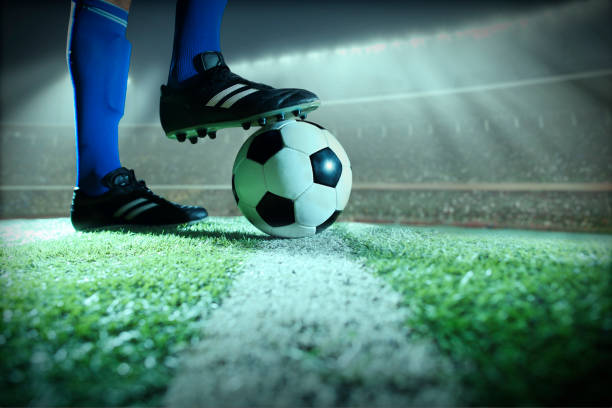 istock Foot on soccer ball mid field line 1159866090