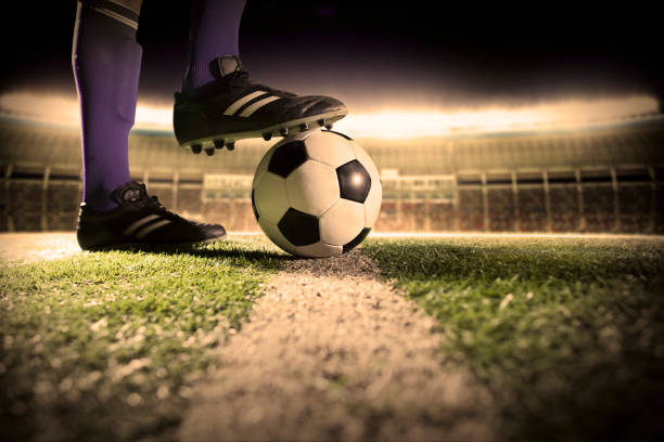 istock Foot on soccer ball mid field line 1159866091