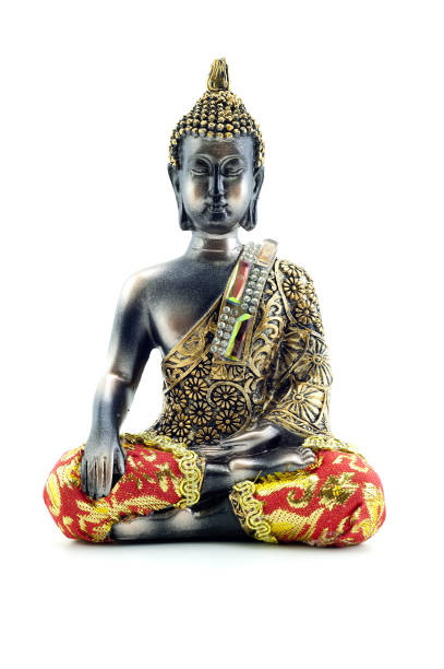 Close-up of a serene Buddha statue in meditation pose, illuminated by warm sunset light in a tranquil outdoor setting.