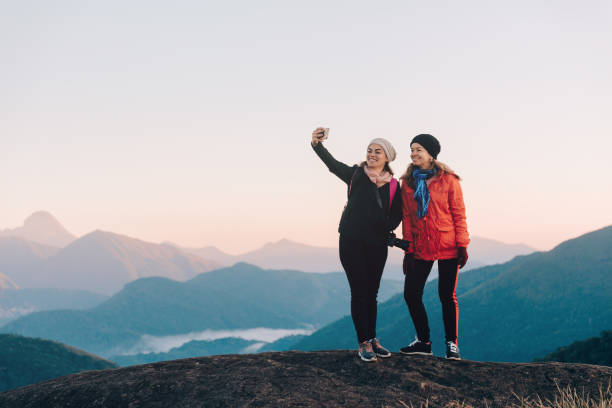 Two mid adult women taking a selfie outdoors at Serra dos Orgaos National Park Two mid adult women taking a selfie outdoors at Serra dos Orgaos National Park glengarry cap stock pictures, royalty-free photos & images