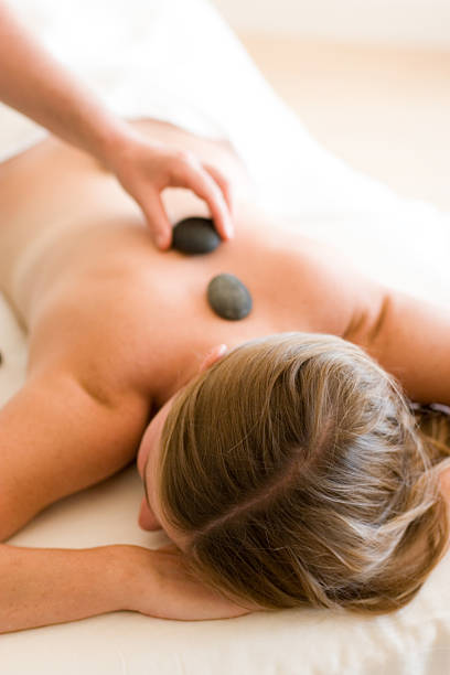 gorący kamień terapii - massage therapist lastone therapy massaging spa treatment zdjęcia i obrazy z banku zdjęć