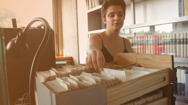 istock Young woman Librarian labelling books with barcode stickers 1159877314