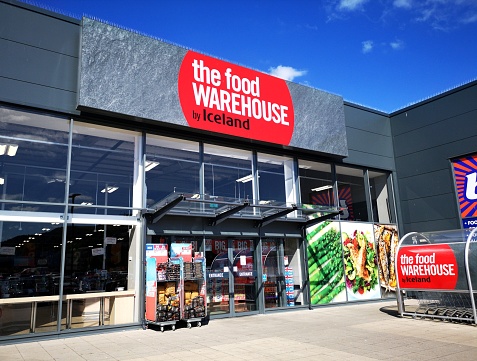 Swansea, UK: July 03, 2019: Exterior of The Food Warehouse by Iceland frozen food supermarket with merchandise on display.