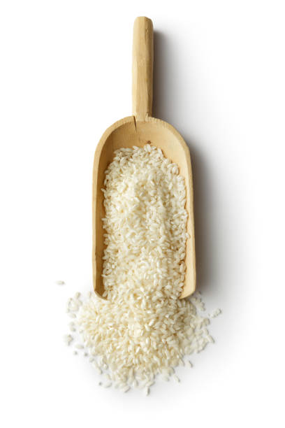 cereali: riso in scoop isolato su sfondo bianco - brown rice rice healthy eating organic foto e immagini stock
