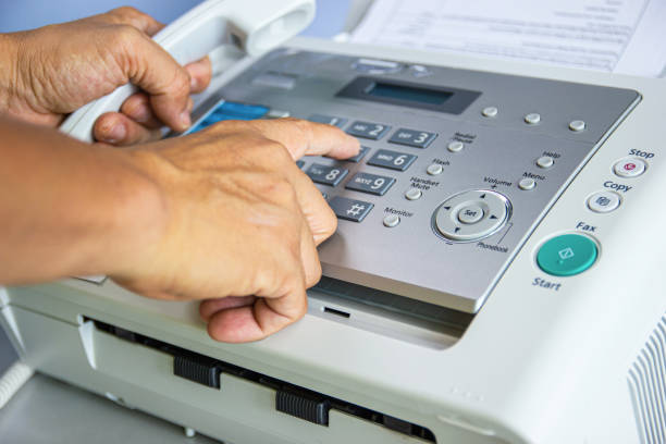 istock hand man are using a fax machine in the office Business concept 1159889259