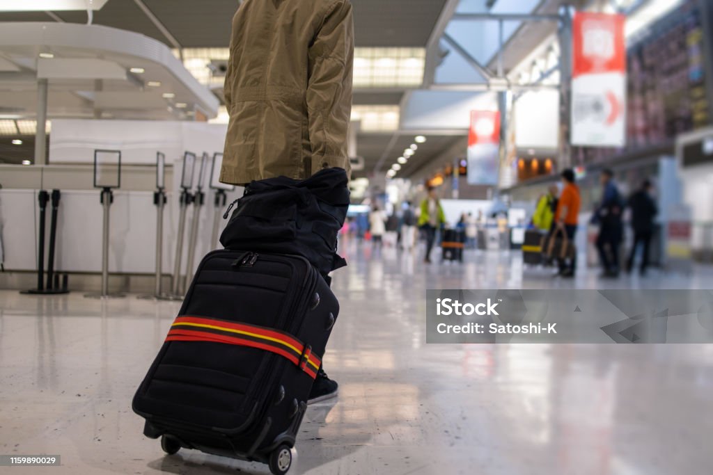 Teenage boy walking in airport for solo trip Airport Stock Photo