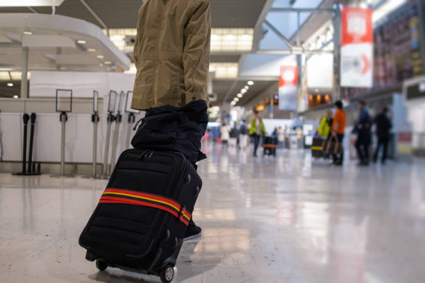 Teenage boy walking in airport for solo trip stock photo
