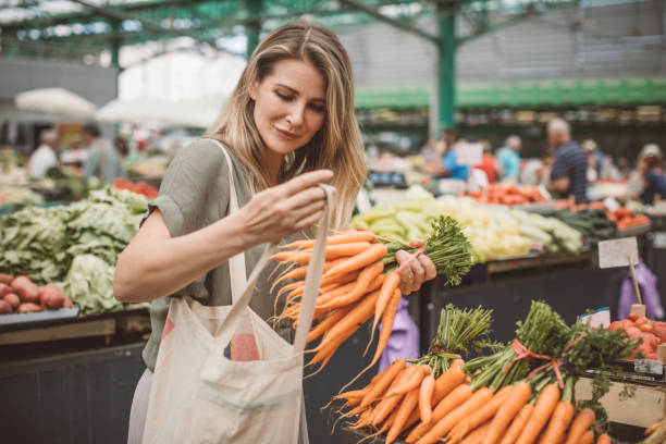 Healthy food for healthy life Cheerful woman selecting fresh vegetables in market, everything is fresh and organic farmers market healthy lifestyle choice people stock pictures, royalty-free photos & images