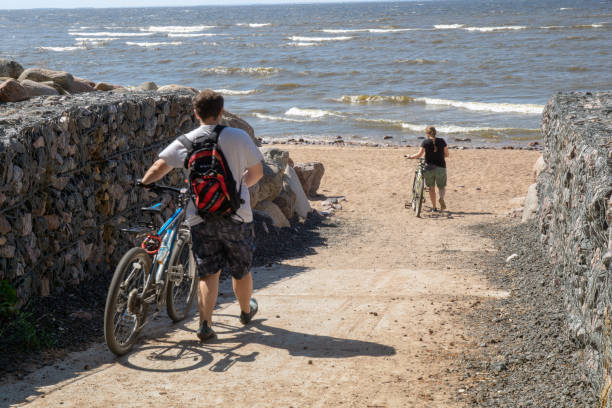 Couple riding bikes on beach boardwalk