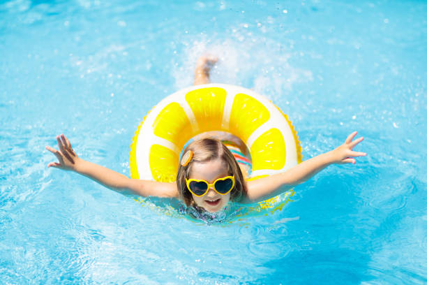 bambino in piscina su ring giocattolo. i bambini nuotano. - inflatable ring water wings swimming pool float foto e immagini stock