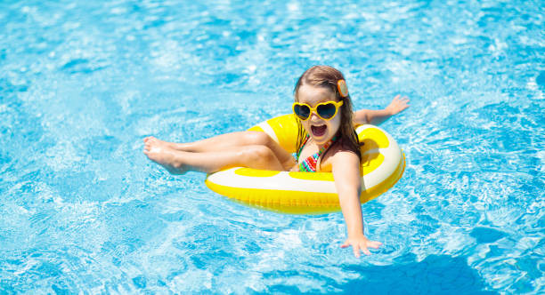 bambino in piscina su ring giocattolo. i bambini nuotano. - inflatable ring water wings swimming pool float foto e immagini stock