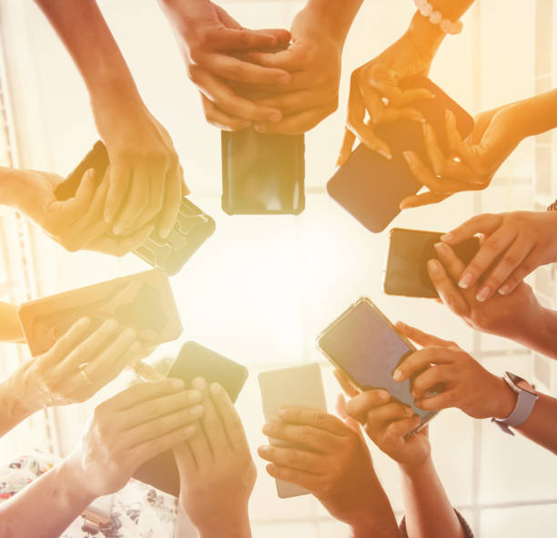 istock Group Of People Standing In Circle Using Smartphone 1159904296