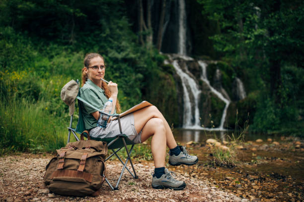 istock Woman biologist contemplating by the waterfall 1159904377