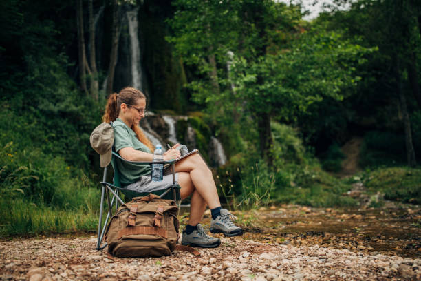 istock Woman biologist taking notes by the waterfall 1159904385