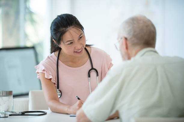 istock Female physician in medical consultation with senior man 1159909708