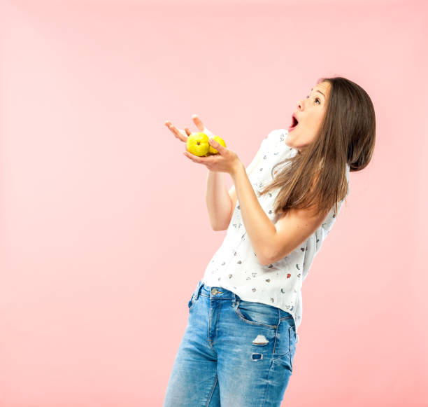 Young Adult Catching a Pear Young Adult Catching a Pear. gasping stock pictures, royalty-free photos & images