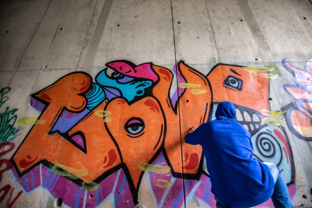 istock Unrecognizable Person Drawing Colorful Grafitti in Highway Underpass 1159912432