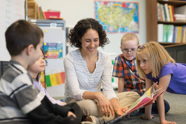 istock Female teacher reading to her first grade students 1159912433