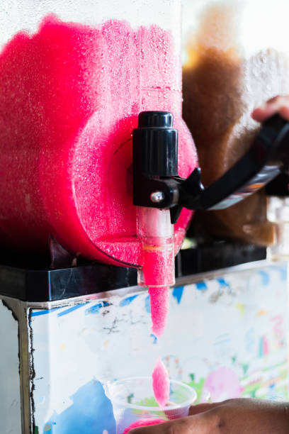 istock Human hand serving slushy drink from slushy  machine 1159925802