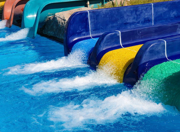 istock Multi-colored water slides with water jets in the blue pool 1159927483