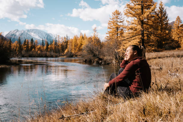 istock Girl resting outdoors sitting by the river 1159935033