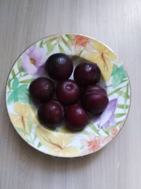 istock Plate with juicy plums on a light table 1159941629