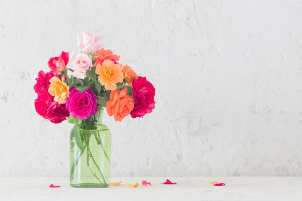 istock roses in vase on background white wall 1159947413