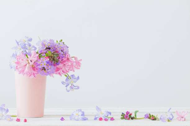 blue and pink spring  flowers in vase on white table