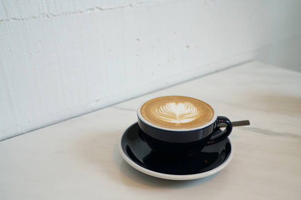 istock Hot Latte - A cup of coffee with milk and beautiful leaf pattern latte art on marble table and blurred background, Perfect for breakfast time. 1159954801