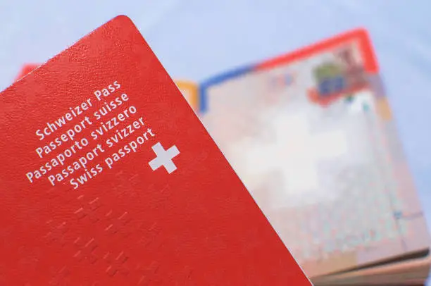 Close up view of one Swiss passport with a blurred open swiss passport on the background