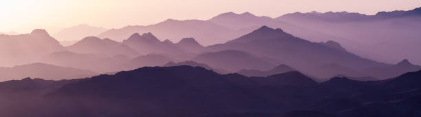istock Beautiful view from the mountain. Panorama. Mountain range with visible silhouettes through the morning blue fog 1159956888