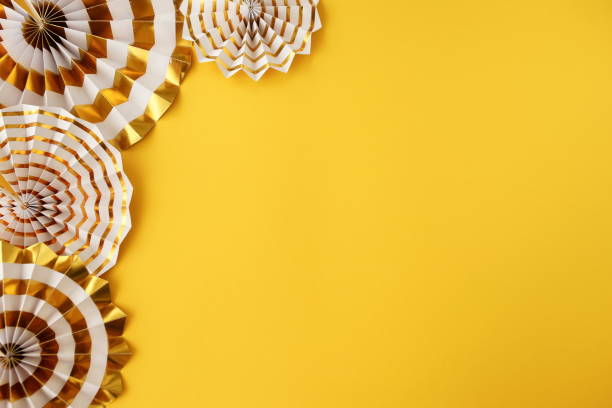 istock party frame decorations in gold colors on  yellow color background with empty copy space for text. holiday and celebration concept for postcard or invitation. top view 1159960007