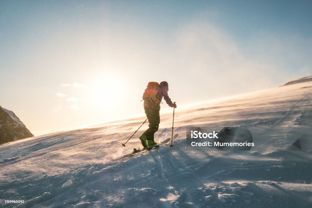 Man Skifahrer mit Rucksack Trekking auf Schneeberg mit Sonnenlicht - Lizenzfrei Skifahren Stock-Foto