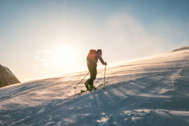 man skifahrer mit rucksack trekking auf schneeberg mit sonnenlicht - snow walking stock-fotos und bilder