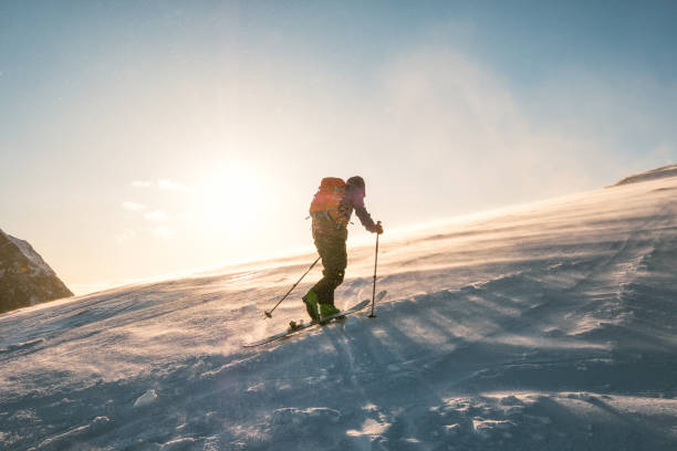 sciatore uomo con zaino trekking su montagna neve con luce solare - skiing winter snow mountain foto e immagini stock
