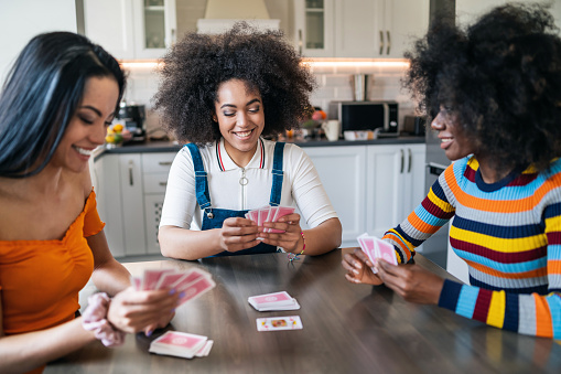 Three girls at home playing cards