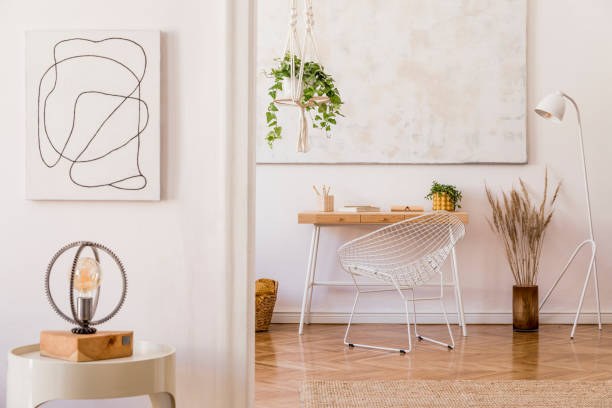 istock Minimalistic boho interior with design and handmade macrame shelf planter hanger for indoor plants, wooden desk, armchair, lamp, white cube and elegant accessories. Stylish home decor. White walls. 1159966924
