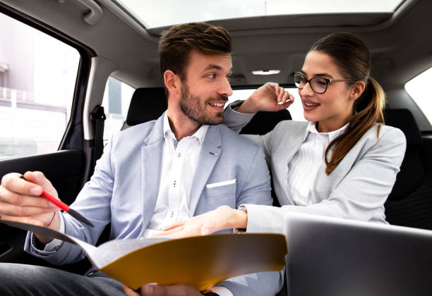 istock Young business people working together while traveling by a car. 1159968132