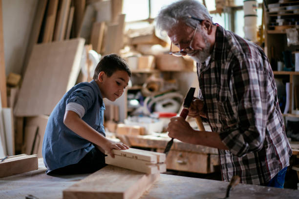 istock Senior carpenter and his grandson having fun in the workshop 1159968355